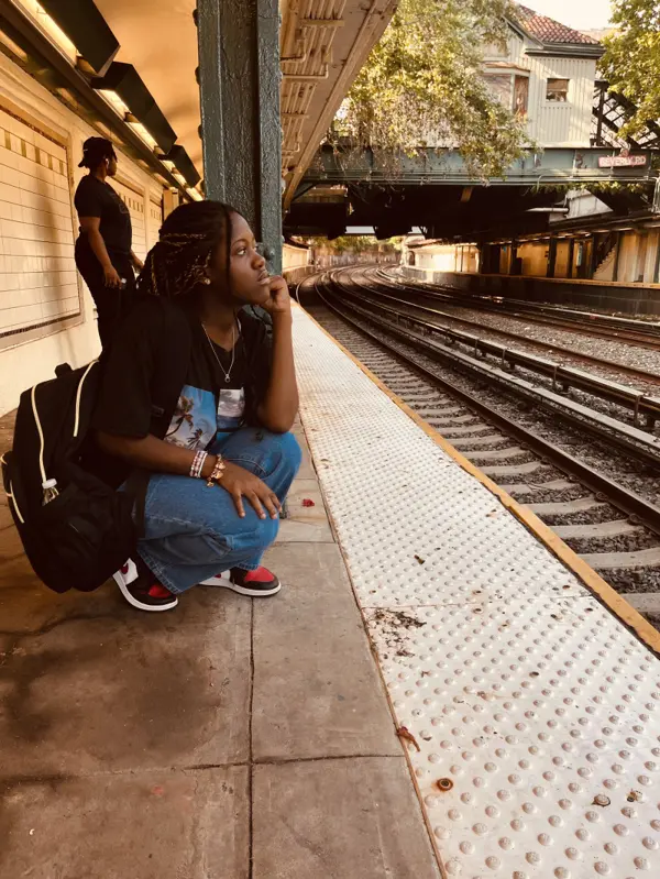 Rose waiting on a train platform on her first day of high school