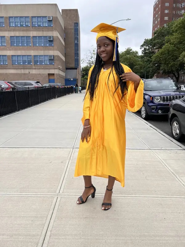 Rose in a yellow cap and gown at her middle school graduation